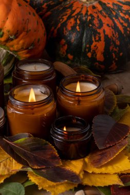 Soya mumları cam kavanozlarda yanar. Ağaç yaprakları, balkabağım. Evdeki rahatlık. Kahverengi kavanozdaki mum. Koku ve ışık. Kokulu el yapımı mum. Aroma terapisi. Sonbahar havası. Sonbaharda rahat ev dekorasyonu.