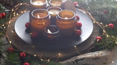 Soya mumları cam kavanozlarda yanar. Evdeki rahatlık. Kahverengi kavanozdaki mum. Koku ve ışık. Kokulu el yapımı mum. Aroma terapisi. Noel ağacı ve kış havası. Sıcak ev dekorasyonu. Kırmızı toplar dekorasyonu