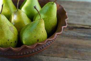 Ahşap arka planda armutlar. Meyve hasadı. Sonbahar hala hayattır. Armut çeşitliliği Bera Konferansı.