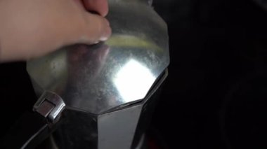 Kahve bir gayzer kahve makinesinde hazırlanıyor. İçki, yakın plandaki İtalyan kahve cezvesine dökülüyor. Ev yapımı kahvaltı için güzel kokulu tonik. Klasik moka potu dolduran espresso