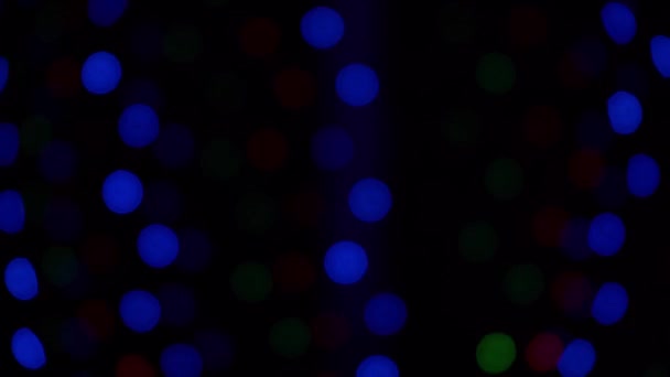 ボケはガーランドを照らす 焦点をぼかした ガーランドが点滅している 夜の街の灯 12月のクリスマス気分 冬の家の窓 多色光4K映像上の黒の背景 — ストック動画