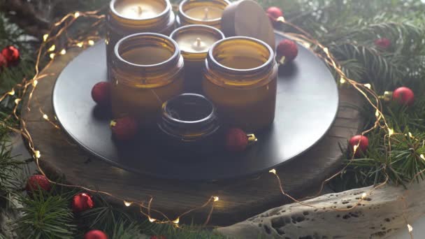 大豆蜡烛在玻璃瓶中燃烧 在家里很舒服把蜡烛放在棕色的罐子里 光芒四射有香味的手工蜡烛芳香疗法 圣诞树和冬天的心情 舒适的家居装饰 红球装饰 — 图库视频影像