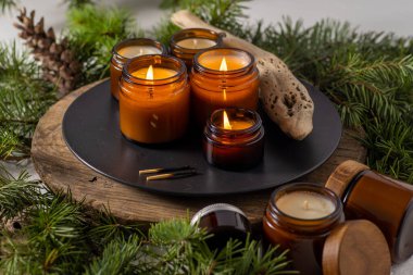 Soya mumları cam kavanozlarda yanar. Evdeki rahatlık. Kahverengi kavanozdaki mum. Koku ve ışık. Kokulu el yapımı mum. Aroma terapisi. Noel ağacı ve kış havası. Hoş bir dekor. Şenlikli dekorasyon