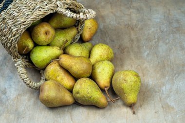 Ahşap bir arka planda sepetteki armutlar. Meyve hasadı. Sonbahar hala hayattır. Armut çeşitliliğinde Bera Konferansı. Vitamin yiyeceği..
