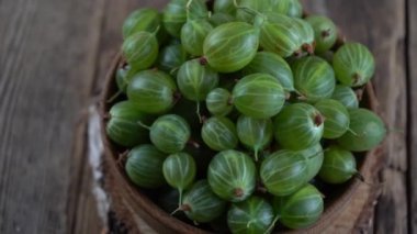 Tahta bir kasede yeşil bektaşi üzümü. Tahta bir masada böğürtlen topla. Bektaşi üzümü yaz vitamini yiyeceği.