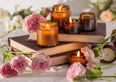 A set of different aroma candles in brown glass jars. Scented handmade candle. Soy candles are burning in a jar. Aromatherapy and relax in spa and home. Fire in brown jar.