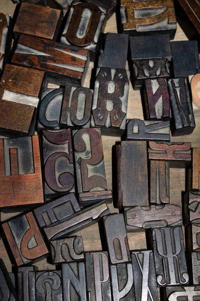 Set of old wooden letters for typography. Vintage background. Letter stamp for printing books. Letterpress alphabet with wooden blocks. Collection of various wood type-setting letter block