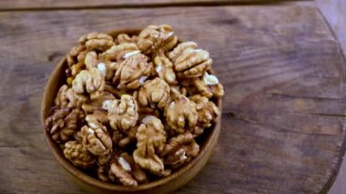 Nuts in a bowl. Healthy food top view. Nut without shell on a plate. Whole and half walnuts kernels. Peeled walnut.