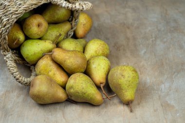 Ahşap bir arka planda sepetteki armutlar. Meyve hasadı. Sonbahar hala hayattır. Armut çeşitliliğinde Bera Konferansı. Vitamin yiyeceği..