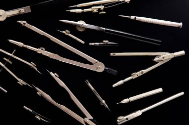 Compass for drawing. Set of old different compasses. Retro metal compasses and drafting tools on a black background. Drawing pen. Tool for study draw