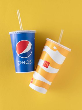Pepsi Coca Cola 'ya karşı. Mavi ve sarı McDonalds bardağı. Kapaklı kağıt bardak. Paket servis içkisi. McDonalds logosu. Ukraynalı, Kyiv - 02 Mart 2023.