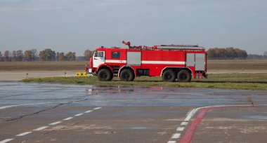 Red fire truck at the airport. Outdoor transportation car. Airport fire engine on the runway. Kyiv, Ukraine - June 27, 2020