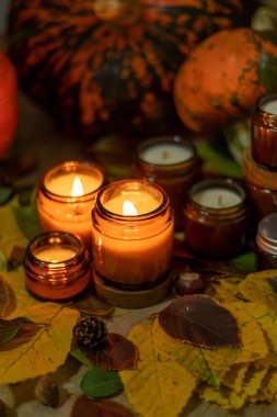 Soya mumları cam kavanozlarda yanar. Ağaç yaprakları, balkabağım. Evdeki rahatlık. Kahverengi kavanozdaki mum. Koku ve ışık. Kokulu el yapımı mum. Aroma terapisi. Sonbahar havası. Sonbaharda rahat ev dekorasyonu.