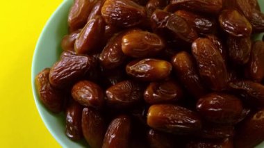 Tarihler. Hurmalıkların meyveleri. Sağlıklı bir atıştırmalık kasesi. Lezzetli kuru tarihler tabakta. Tarih hasadı Ramazan 'ı simgeliyor.