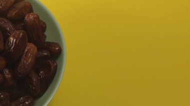 Tarihler. Hurmalıkların meyveleri. Sağlıklı bir atıştırmalık kasesi. Lezzetli kuru tarihler tabakta. Tarih hasadı Ramazan 'ı simgeliyor.