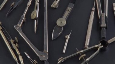 Compass for drawing. Set of old different compasses. Retro metal compasses and drafting tools on a black background. Drawing pen. Tool for study draw