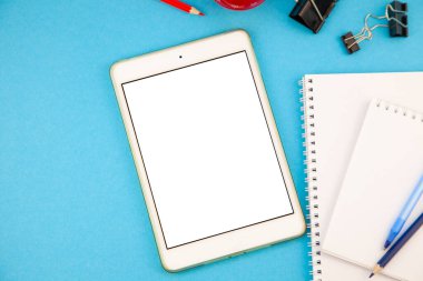 Tablet maketi mavi arkaplan üst görünümü. İşyeri fotokopi alanı. Not defteri, defter, kalem. Çalış ve planla. Kendi kendini öğrenme. Çevrimiçi iş kursu. Uzaktan eğitim. Boş ekran tabletinin düzlüğü