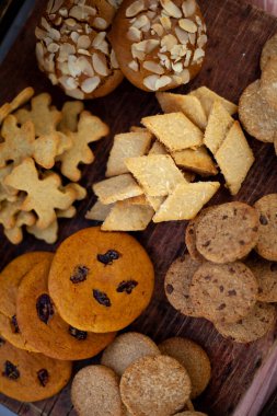 Farklı kurabiyeler. Yemek arkaplanı. Ev yapımı kahvaltı kurabiyesi manzarası. Tatlı badem cipsi. Fırın aşçısı. Pasta pişir. Hindistan cevizi, hecelenen kuru üzüm.