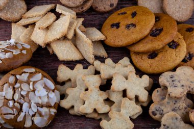 Farklı kurabiyeler. Yemek arkaplanı. Ev yapımı kahvaltı kurabiyesi manzarası. Tatlı badem cipsi. Fırın aşçısı. Pasta pişir. Hindistan cevizi, hecelenen kuru üzüm.