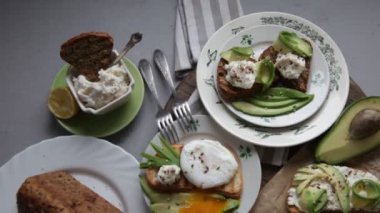 Sandwiches with avocado, soft cheese and sprinkled with flax and sesame seeds. Breakfast is on the table. Plate with healthy food. Avocado toast. Poached egg.