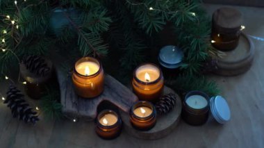 Soya mumları cam kavanozlarda yanar. Evdeki rahatlık. Kahverengi kavanozdaki mum. Koku ve ışık. Kokulu el yapımı mum. Aroma terapisi. Noel ağacı ve kış havası. Sıcak ev dekorasyonu. Şenlikli dekorasyon.