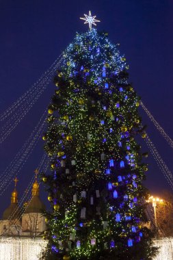 Geceleri sokak şehri Noel ağacı. Çelenkler yanıyor. Tatil süsleri ve oyuncaklar. Işıkların çelengi. Güzel aydınlatmalar. Noel arkaplanı. Şenlikli kış şehri manzarası