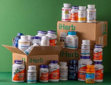 iHerb kutusundan vitaminler, mineraller ve mikro besinler. Bir sürü farklı kavanoz. Biyolojik olarak aktif gıda katkı maddeleri. Beslenme takviyesi çevrimiçi alınıyor. Sağlık için ilaçlar. Kyiv, Ukrayna - 13 Temmuz 2022