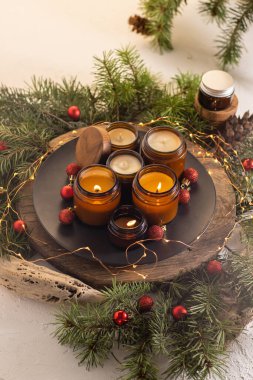 Soya mumları cam kavanozlarda yanar. Evdeki rahatlık. Kahverengi kavanozdaki mum. Koku ve ışık. Kokulu el yapımı mum. Aroma terapisi. Noel ağacı ve kış havası. Hoş bir dekor. Şenlikli çelenk dekorasyonu