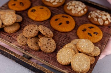 Farklı kurabiyeler. Yemek arkaplanı. Ev yapımı kahvaltı kurabiyesi manzarası. Tatlı badem cipsi. Fırın aşçısı. Pasta pişir. Hindistan cevizi, hecelenen kuru üzüm.