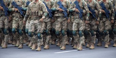 Askeri askerler silahlı bir geçit töreninde yürüyorlar. Piksel üniforması. Asker bacakları. Savaş geçmişi. Özel kuvvetler ve piyade botları. Erkekler güç kazanır.
