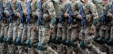 Askeri askerler silahlı bir geçit töreninde yürüyorlar. Piksel üniforması. Asker bacakları. Savaş geçmişi. Özel kuvvetler ve piyade botları. Erkekler güç kazanır.