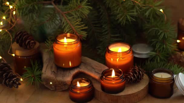 大豆蜡烛在玻璃瓶中燃烧 在家里很舒服把蜡烛放在棕色的罐子里 光芒四射有香味的手工蜡烛芳香疗法 圣诞树和冬天的心情 舒适的家居装饰 节日装饰 — 图库视频影像