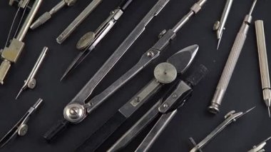 Compass for drawing. Set of old different compasses. Retro metal compasses and drafting tools on a black background. Drawing pen. Tool for study draw