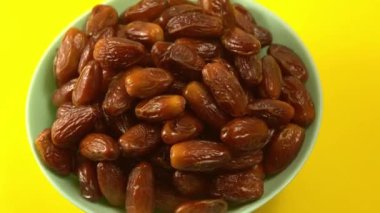 Tarihler. Hurmalıkların meyveleri. Sağlıklı bir atıştırmalık kasesi. Lezzetli kuru tarihler tabakta. Tarih hasadı Ramazan 'ı simgeliyor.