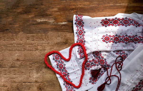 stock image Ukrainian clothes embroidered white shirt. Red and black threads on a wooden background. Vyshyvanka is a symbol of Ukraine. Embroidery copy space. Cross stitching.