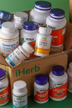 iHerb kutusundan vitaminler, mineraller ve mikro besinler. Bir sürü farklı kavanoz. Biyolojik olarak aktif gıda katkı maddeleri. Beslenme takviyesi çevrimiçi alınıyor. Sağlık için ilaçlar. Kyiv, Ukrayna - 13 Temmuz 2022