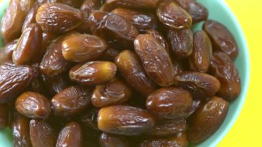 Tarihler. Hurmalıkların meyveleri. Sağlıklı bir atıştırmalık kasesi. Lezzetli kuru tarihler tabakta. Tarih hasadı Ramazan 'ı simgeliyor.