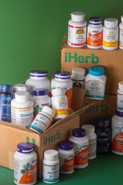 iHerb kutusundan vitaminler, mineraller ve mikro besinler. Bir sürü farklı kavanoz. Biyolojik olarak aktif gıda katkı maddeleri. Beslenme takviyesi çevrimiçi alınıyor. Sağlık için ilaçlar. Kyiv, Ukrayna - 13 Temmuz 2022
