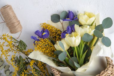 Spring bouquet of flowers. Irises, tulips, mimosa and eucalyptus. Yellow and blue flower. Bud close-up. Floral background. Purple iris, white double tulip. Gift. March mood.