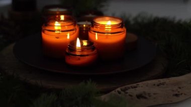 Soya mumları cam kavanozlarda yanar. Gece çok karanlık. Aromaterapi ve rahatlama. Evdeki rahatlık. Kahverengi kavanozdaki mum. Koku ve ışık. Kokulu el yapımı mum. Aroma terapisi