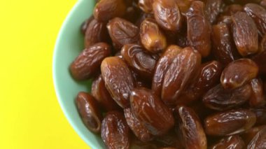 Tarihler. Hurmalıkların meyveleri. Sağlıklı bir atıştırmalık kasesi. Lezzetli kuru tarihler tabakta. Tarih hasadı Ramazan 'ı simgeliyor.