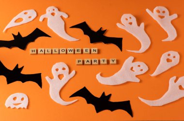 White ghosts and bat craft for Halloween party. Wrapping paper ghost on orange background top view. Cartoon creepy Whisper. DIY hand made. Set boo characters. Word wooden letter phrase.