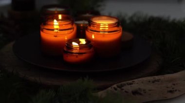 Soya mumları cam kavanozlarda yanar. Gece çok karanlık. Aromaterapi ve rahatlama. Evdeki rahatlık. Kahverengi kavanozdaki mum. Koku ve ışık. Kokulu el yapımı mum. Aroma terapisi