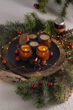 Soya mumları cam kavanozlarda yanar. Evdeki rahatlık. Kahverengi kavanozdaki mum. Koku ve ışık. Kokulu el yapımı mum. Aroma terapisi. Noel ağacı ve kış havası. Hoş bir dekor. Şenlikli çelenk dekorasyonu