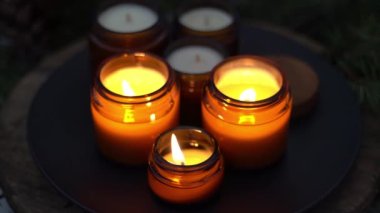 Soya mumları cam kavanozlarda yanar. Gece çok karanlık. Aromaterapi ve rahatlama. Evdeki rahatlık. Kahverengi kavanozdaki mum. Koku ve ışık. Kokulu el yapımı mum. Aroma terapisi