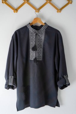 Ukrayna giysileri nakışlı erkek gömleği. Mavi gri ve siyah iplikler arka planda. Vyshyvanka Ukrayna 'nın bir sembolüdür. Nakış haçı dikişleri. Ulusal Ukrayna dikişi. Geleneksel giyim sembolü.