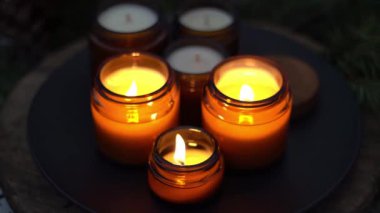 Soya mumları cam kavanozlarda yanar. Gece çok karanlık. Aromaterapi ve rahatlama. Evdeki rahatlık. Kahverengi kavanozdaki mum. Koku ve ışık. Kokulu el yapımı mum. Aroma terapisi