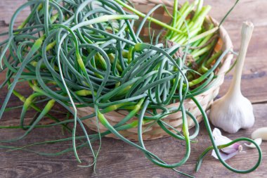 Sarımsaklı oklar. Masada bir sürü yeşillik var. Sebze, sağlıklı vitamin yiyeceği. Salata ve güveç için yeşil saplı fidanlar. Vejetaryen taze otlar, Çin mutfağı..