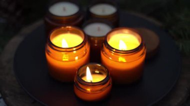 Soya mumları cam kavanozlarda yanar. Gece çok karanlık. Aromaterapi ve rahatlama. Evdeki rahatlık. Kahverengi kavanozdaki mum. Koku ve ışık. Kokulu el yapımı mum. Aroma terapisi