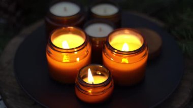 Soya mumları cam kavanozlarda yanar. Gece çok karanlık. Aromaterapi ve rahatlama. Evdeki rahatlık. Kahverengi kavanozdaki mum. Koku ve ışık. Kokulu el yapımı mum. Aroma terapisi